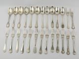 a lot of silver spoons and forks laid out on a table