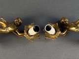 two gold figurines that have eyes on them