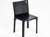 the black chair is sitting on a white surface with a white background