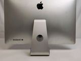 a silver apple computer sitting on top of a white table