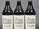 three bottles of red wine sitting on top of a table