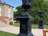 a black urn sitting in the middle of a grassy area