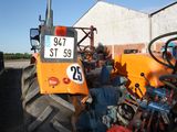 a tractor with a number plate on it parked in front of a building