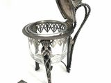 a silver plate with a spoon and spoon rest next to it