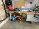 a desk with a chair and a computer on it in a garage