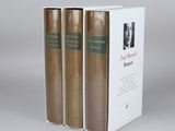 three books are stacked on top of each other on a table