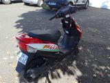 a scooter parked in a parking lot with cars in the background