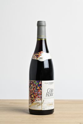 the bottle of wine is sitting on the table with sprinkles on it