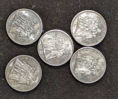 cinq pièces d'argent empilées les unes sur les autres sur une surface noire
