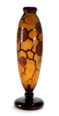 a vase that has shells on it on a stand