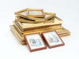 a pile of framed pictures on a white surface