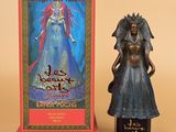 une statue représentant une femme tenant une bouteille de vin à côté d'un carton de vin