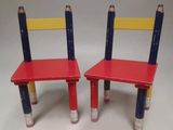 pair of red and blue wooden chairs with pencils on them