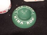 a green bowl with a white lid sitting on a table