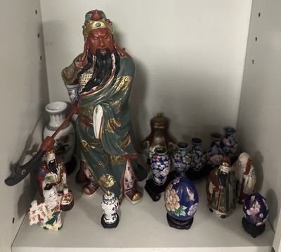 une étagère sur laquelle sont disposées de nombreuses figurines asiatiques