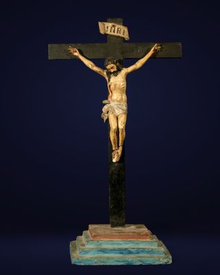 a statue of jesus on the cross on a blue background