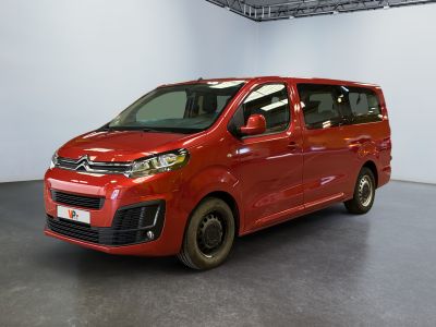 La camionnette rouge est garée dans une grande pièce au sol noir.