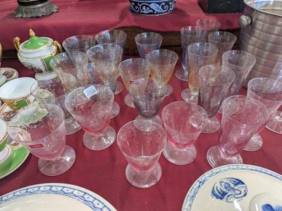 many glasses and plates on a table with a red table cloth