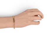 gold plated bracelet on a mannequin hand on a white background