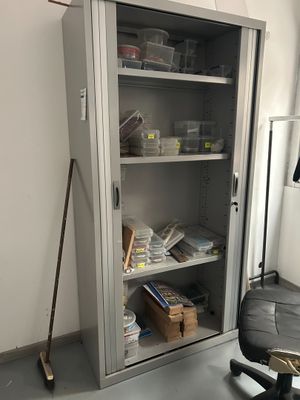 une armoire métallique avec des étagères et une chaise dans un coin