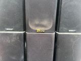 several black speakers stacked on top of each other in a room