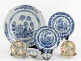 Plusieurs assiettes et bols bleus et blancs sont posés sur une surface blanche.