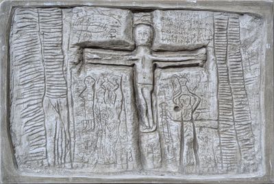 relief représentant un homme sur une croix, sur un mur d'une église