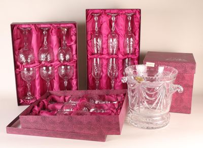 three wine glasses and a glass vase in a pink box