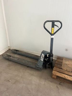 une palette posée à côté d'une pile de palettes en bois