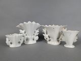 three white vases are sitting next to each other on a table
