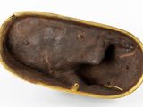 a bronze figurine of a dog in a bowl on a white surface