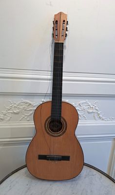 a guitar sitting on top of a table in a room
