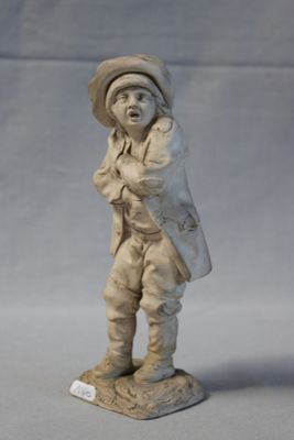 une petite statue représentant un homme avec un chapeau et un sac