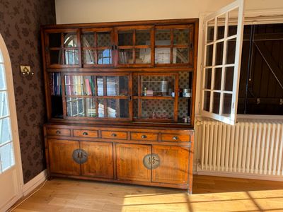a wooden china cabinet in the corner of a room