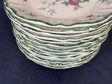 a stack of plates with roses on them on a table
