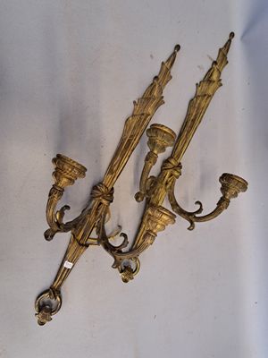 pair of antique brass wall sconces on a white background