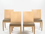 trois chaises en bois aux assises recouvertes de cuir, sur fond blanc