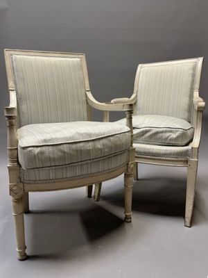 deux chaises blanches dont les accoudoirs et les pieds sont recouverts d'un tissu rayé