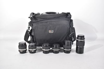 a black camera bag with a lot of lenses on it