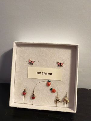 a white box with four pairs of earrings and a sign that says or 37 ' s mill