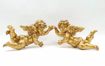 une paire de figurines d'anges en or sur fond blanc