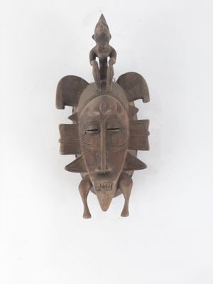 an image of a wooden mask hanging on a wall