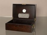 une boîte en bois contenant une horloge, posée sur une table