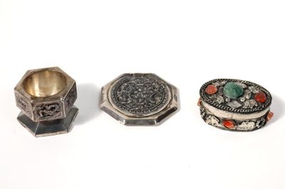 trois bagues en argent et une bague posée sur une surface blanche