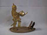 a gold statue of a man holding a teapot