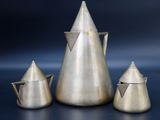 three pieces of silver metal on a blue surface