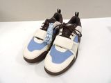 pair of blue and white sneakers with brown laces on a white surface