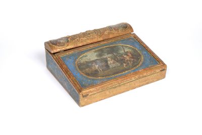 a small box with a painting on it on a white surface