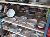 many plates and bowls on the shelves in the kitchen