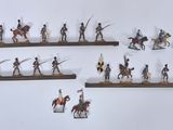 many figurines of people riding horses on a shelf
